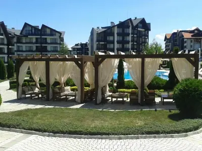 a gazebo with benches in a park with buildings at Aspen golf & Ski resort 2 bedroom apartment E002 in Razlog