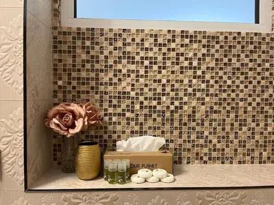 a shelf in a bathroom with a box and flowers at Ellie Soe Apartment Free parking 5 min to Metro in Sofia