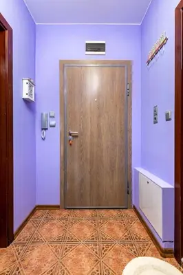 a wooden door in a room with purple walls at City Center Apartment Aleko Konstantinov in Plovdiv