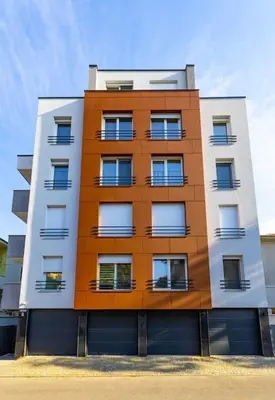 a tall orange and white building with windows at Casa di Marko Stylish apt in the Center in Plovdiv