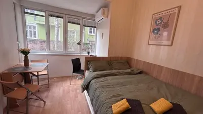 a bedroom with a bed and a table in it at Studio in the heart of Sofia in Sofia