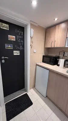 a kitchen with a black door and a refrigerator at Studio in the heart of Sofia in Sofia