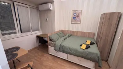 a small bedroom with a bed and a desk at Studio in the heart of Sofia in Sofia