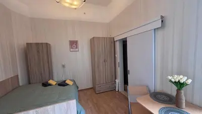 a bedroom with a bed and a table with a vase of flowers at Studio in the heart of Sofia in Sofia