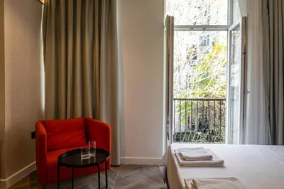 a room with a red chair and a bed and a window at M star rooms, Private Parking, Sofia TOP CENTER in Sofia