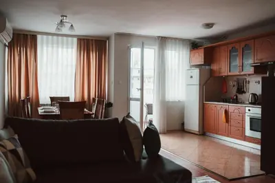 a kitchen and living room with a couch and a table at Apartment Rhea with Terrace & Parking in Plovdiv