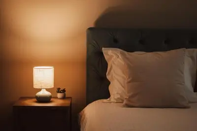 a bedroom with a bed with a lamp on a night stand at Apartment Rhea with Terrace & Parking in Plovdiv