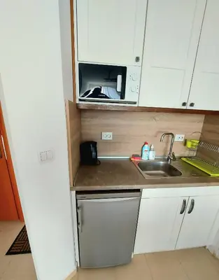 a small kitchen with a sink and a microwave at BELVEDERE Holiday Club VIP 59 in Bansko