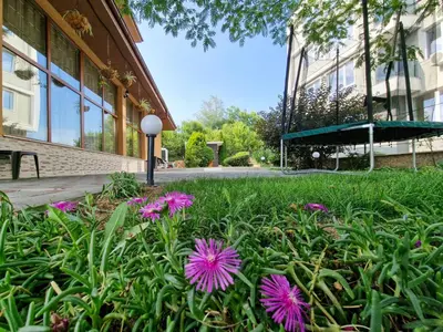 a field of flowers in front of a building at Айляк Клуб Хисаря - Бутиков Хотел&СПА с Elegant Ultra All Inclusive in Hisarya