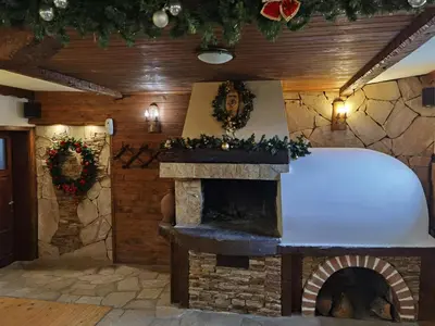 a fireplace in a living room with christmas decorations at Mira Guest House in Dobrinishte