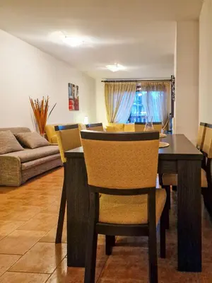 a dining room and living room with a table and chairs at Cozy 2-Bedroom Stay with Parking in OLD INN Bansko by Flat Mаnager in Bansko