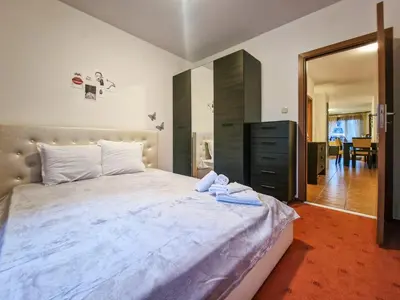 a bedroom with a large bed and a dresser at Cozy 2-Bedroom Stay with Parking in OLD INN Bansko by Flat Mаnager in Bansko