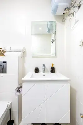 a white bathroom with a sink and a mirror at Bright Windowed Studio 10 mins to the City Centre by Flat Mаnager in Plovdiv