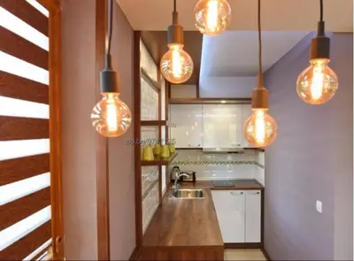 a kitchen with lights hanging from the ceiling at Уютная студия Green Life E 04 in Bansko