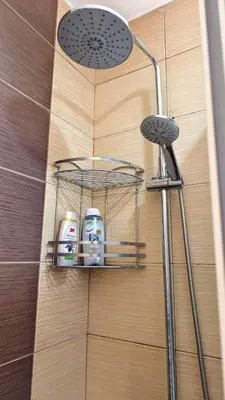 a bathroom with a shower with a rack with two shampoo at Уютная студия Green Life E 04 in Bansko