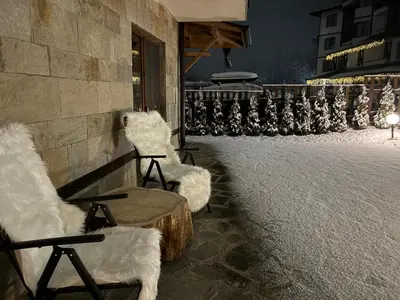 two white chairs sitting outside of a building at Bella Si Relax in Bansko