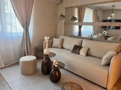 a living room with a white couch and a table at Cozy design 1 bedroom apartment in Bansko