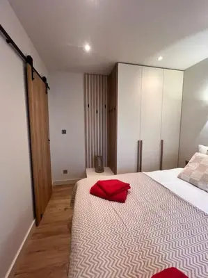 a bedroom with a large bed with red pillows on it at Cozy design 1 bedroom apartment in Bansko