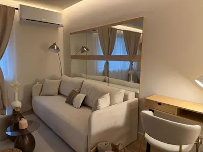a living room with a white couch and a table at Cozy design 1 bedroom apartment in Bansko