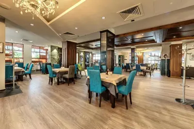 a dining room with tables and chairs and a chandelier at One-bedroom Apartment at Belvedere Holiday Club Complex in Bansko