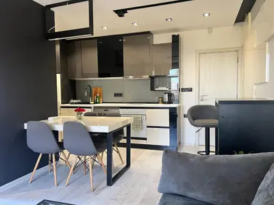 a kitchen with a table and chairs in a room at The Mirror Apartment in Sofia