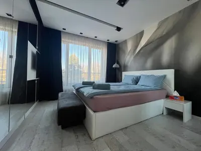 a bedroom with a bed and a large window at The Mirror Apartment in Sofia