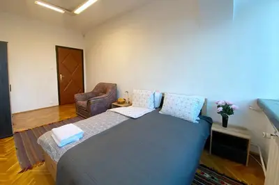 a bedroom with a large bed and a chair at Sofia Office Loft in Sofia