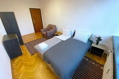 a bedroom with a large bed and a chair at Sofia Office Loft in Sofia