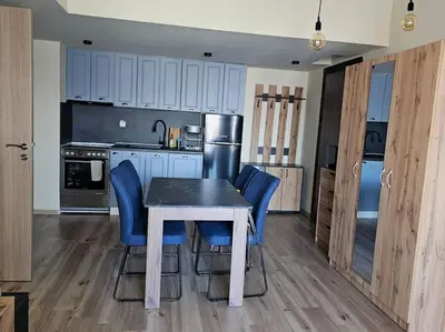 a kitchen with a table and some blue chairs at CROWN Apartment Bansko in Bansko