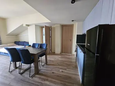 a kitchen with a table and chairs in a room at CROWN Apartment Bansko in Bansko