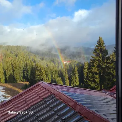 a rainbow over the roof of a house at Pamporovo hotel Snezhanka A640 in Pamporovo