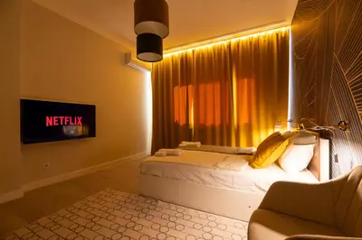 a bedroom with a bed and a tv and a window at Contemporary Vintage, 3BDR Grace Suite in Sofia