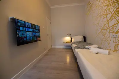 a room with two beds and a tv on the wall at Contemporary Vintage, 3BDR Grace Suite in Sofia
