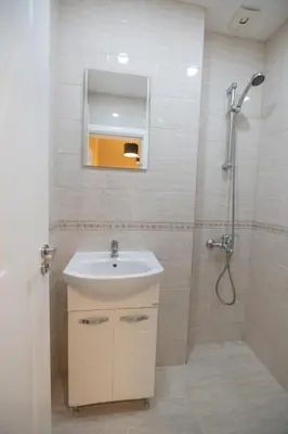a bathroom with a sink and a shower with a mirror at Contemporary Vintage, 3BDR Grace Suite in Sofia