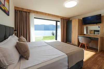a bedroom with a large bed with a large window at Lavalliere Hotel & Villas in Sarnitsa