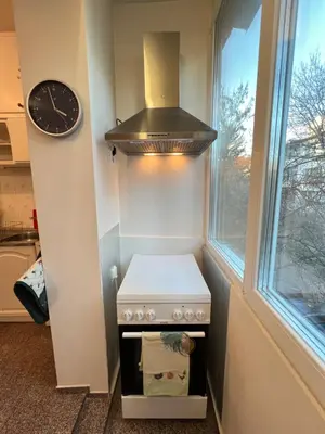 a kitchen with a stove and a clock on the wall at Glasgow 2BDR peaceful Apt 1 min from Metro w WiFi in Sofia