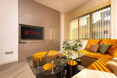 a living room with a couch and a table at Two bedroom apt Karavelov with Private Parking Medical University in Plovdiv