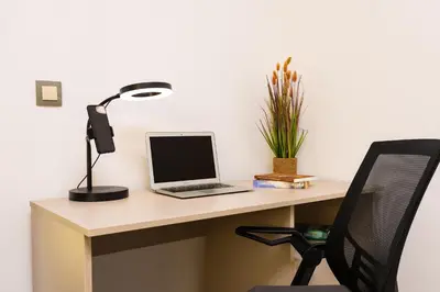 a laptop computer sitting on a desk with a lamp at Two bedroom apt Karavelov with Private Parking Medical University in Plovdiv