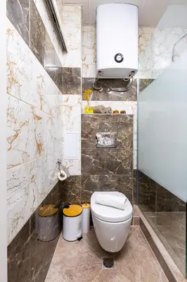 a bathroom with a toilet and a towel dispenser at Two bedroom apt Karavelov with Private Parking Medical University in Plovdiv