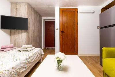 a bedroom with a bed and a vase of flowers at Tiny Secret Place next to MU with Private Parking in Plovdiv