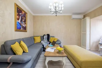 a living room with a blue couch and yellow pillows at The EGO house at Vitoshka Street in Sofia