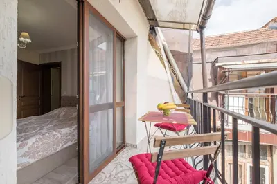 a balcony with a wooden table and a bed at The EGO house at Vitoshka Street in Sofia