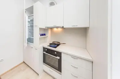 a kitchen with white cabinets and a stove at Sofia Center - Vitoshka apartment in Sofia
