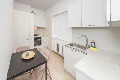a kitchen with a sink and a table with chairs at Sofia Center - Vitoshka apartment in Sofia