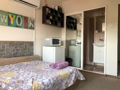 a bedroom with a bed with a purple pillow on it at Rooftop Central Studio in Sofia