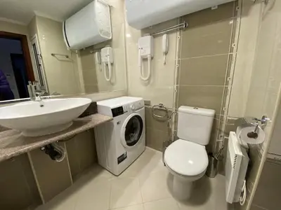 a bathroom with a sink and a washing machine at Ski Lift - NoVi Apartments Bansko in Bansko