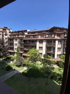 a large apartment building with trees in front of it at Ski Lift - NoVi Apartments Bansko in Bansko