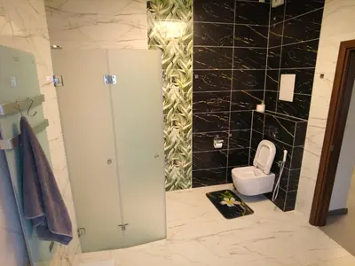 a bathroom with a toilet and a black wall at 4-bedrooms luxury apartment very close to ski lift in Bansko