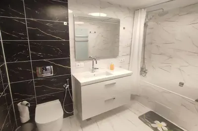 a white bathroom with a sink and a mirror at 4-bedrooms luxury apartment very close to ski lift in Bansko