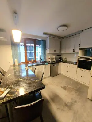 a large kitchen with a table and chairs in it at 4-bedrooms luxury apartment very close to ski lift in Bansko